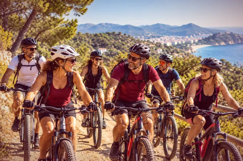 Grupo en bicicleta por un sendero con vistas al mar